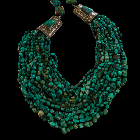 Collar tibetano con 15 vueltas de turquesas, 2 piezas artesanales hechas a mano con plata de ley y turquesas y 8 grandes turquesas tibetanas en la parte posterior. La turquesa es considerada por los tibetanos como un amuleto protector y sanador, que aleja el mal de ojo y las energías perjudiciales. Longitud máxima 110 cm / mínima 75 cm Peso 620 g Tibetan necklace with turquoise and silver. Lula Máiz