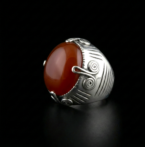 Anillo artesanal hecho a mano con plata y gran cabujón de ágata cornalina, de diseño uigur, comunidad musulmana de Kashgar ( Sinkiang ). Las espirales laterales simbolizan la eternidad. Tamaño 18 Peso 31 g Rining hand made with silver and carnelian cabochon. Lula Maiz.