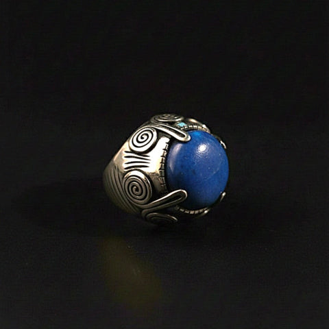 Anillo artesanal hecho a mano con plata de ley y cabujón de lapislázuli. Las espirales laterales simbolizan la eternidad. Diámetro cabujón 2 mm Peso 33 g Ring hand made with sterling silver and lapislazuli cabochon. Lula Máiz