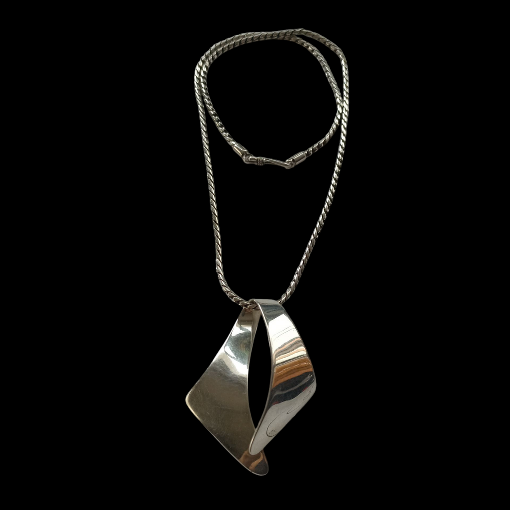 Colgante artesanal de diseño contemporáneo hecho a mano con plata de ley. La cadena es también artesanal de plata de ley. Medidas colgante 6 cm x 4´5 cm / Peso colgante 15 g Longitud cadena 50 cm/ Peso cadena 20 g Pendant hand made with sterling silver. Lula Máiz