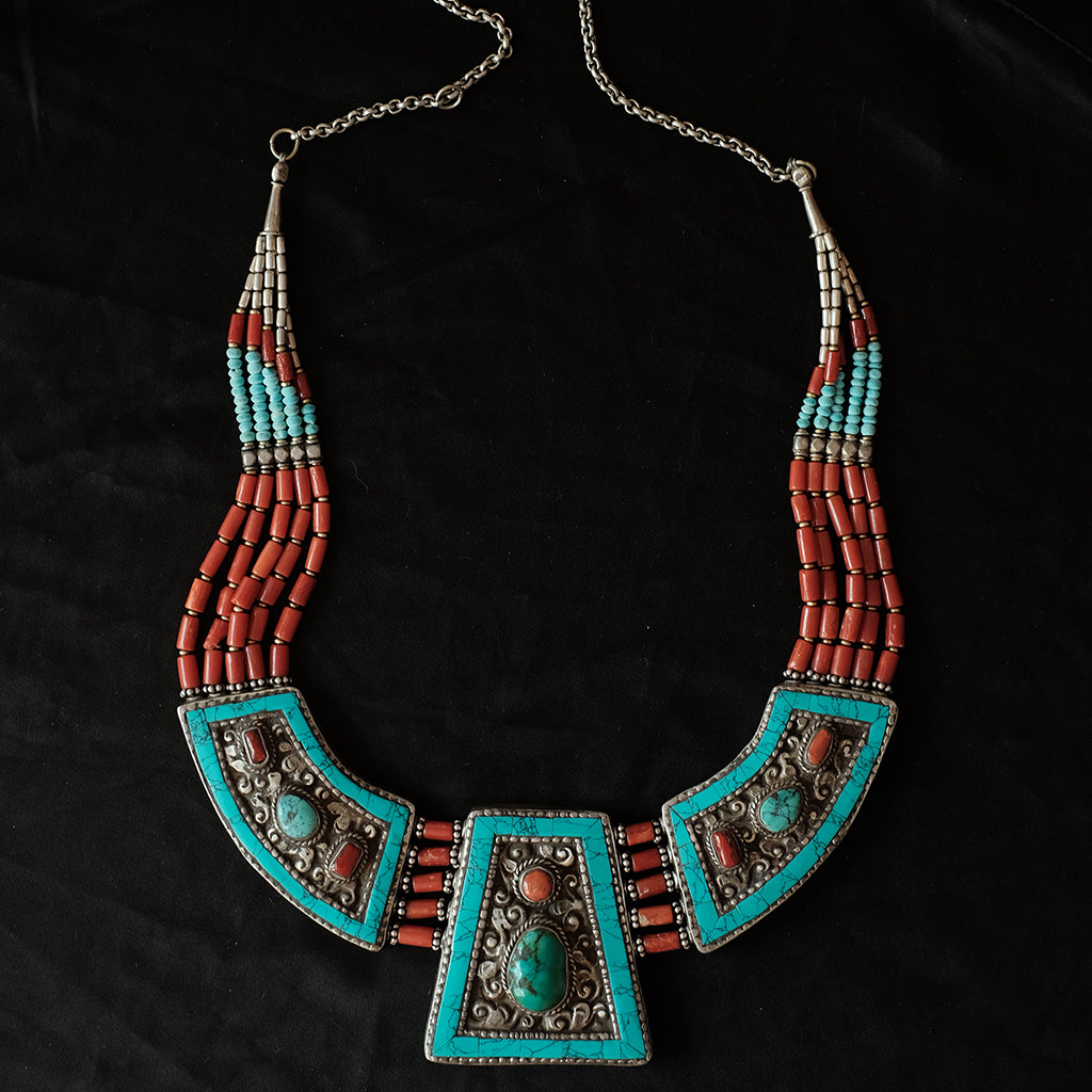 Collar artesanal de Tibet hecho a mano con exquisito trabajo orfebre en la parte posterior, con motivos zoomorfos y 5 vueltas de cuentas de coral. Tiene dos posibilidades de longitud, con o sin cadena. Longitud 58 cm ( con cadena ) 50 ( sin cadena) Medidas pieza central 5´5 cm x 5 cm Peso 155 g Tibetan necklace with coral.