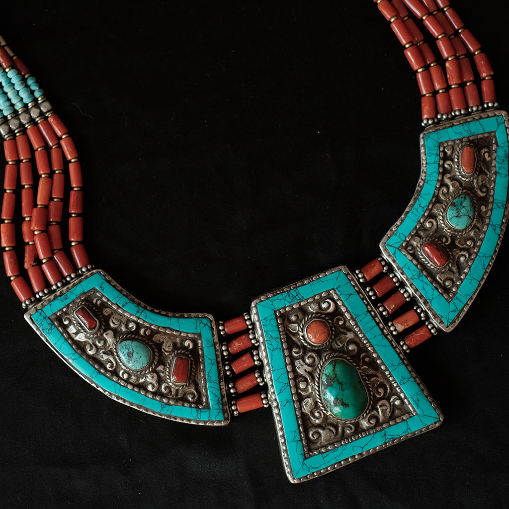 Collar artesanal de Tibet hecho a mano con exquisito trabajo orfebre en la parte posterior, con motivos zoomorfos y 5 vueltas de cuentas de coral. Tiene dos posibilidades de longitud, con o sin cadena. Longitud 58 cm ( con cadena ) 50 ( sin cadena) Medidas pieza central 5´5 cm x 5 cm Peso 155 g Tibetan necklace with coral.