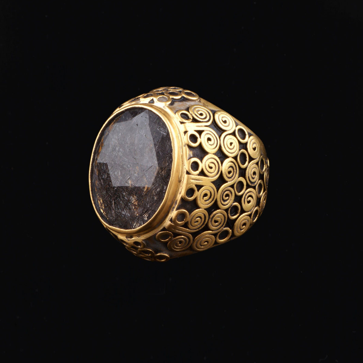 Anillo artesanal hecho a mano con plata de ley, baño de oro mateado y cuarzo ahumado rutilado facetado. Tamaño 19 Medidas rutilo 20 mm x 15 mm Peso 30 g Ring hand made with gold plated silver and smoky rutile. Lula Máiz