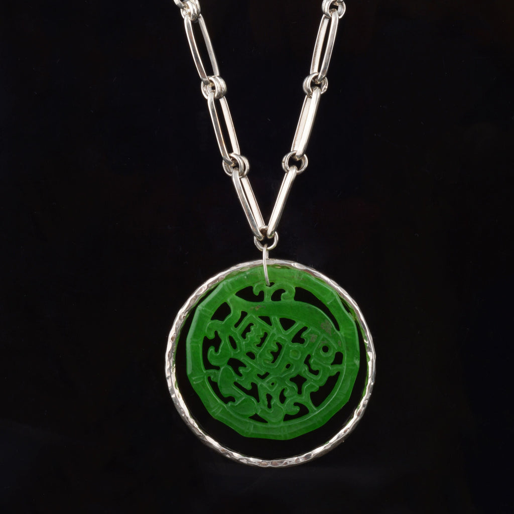 Colgante artesanal hecho a mano con plata martele y jade , montado en cadena de eslabones de plata de ley y cierre de mosquetón. Diámetro colgante jade 4´5 cm Longitud cadena 80 cm Peso 76 gr. Handcrafted pendant made with silver and carved jade. Lula Máiz