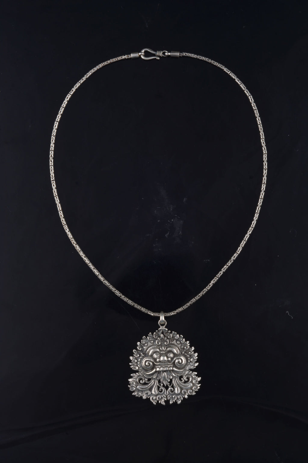 Colgante artesanal hecho a mano con plata de ley representando a Barong, criatura mítica de la isla de Bali, rey de los espíritus del bien, que adopta forma de animal como protector del bosque. Medidas 5 cm x 4 cm Largo cadena 45 cm Peso colgante 19 g Peso cadena 14 g Handcrafted silver pendant. Lula Máiz