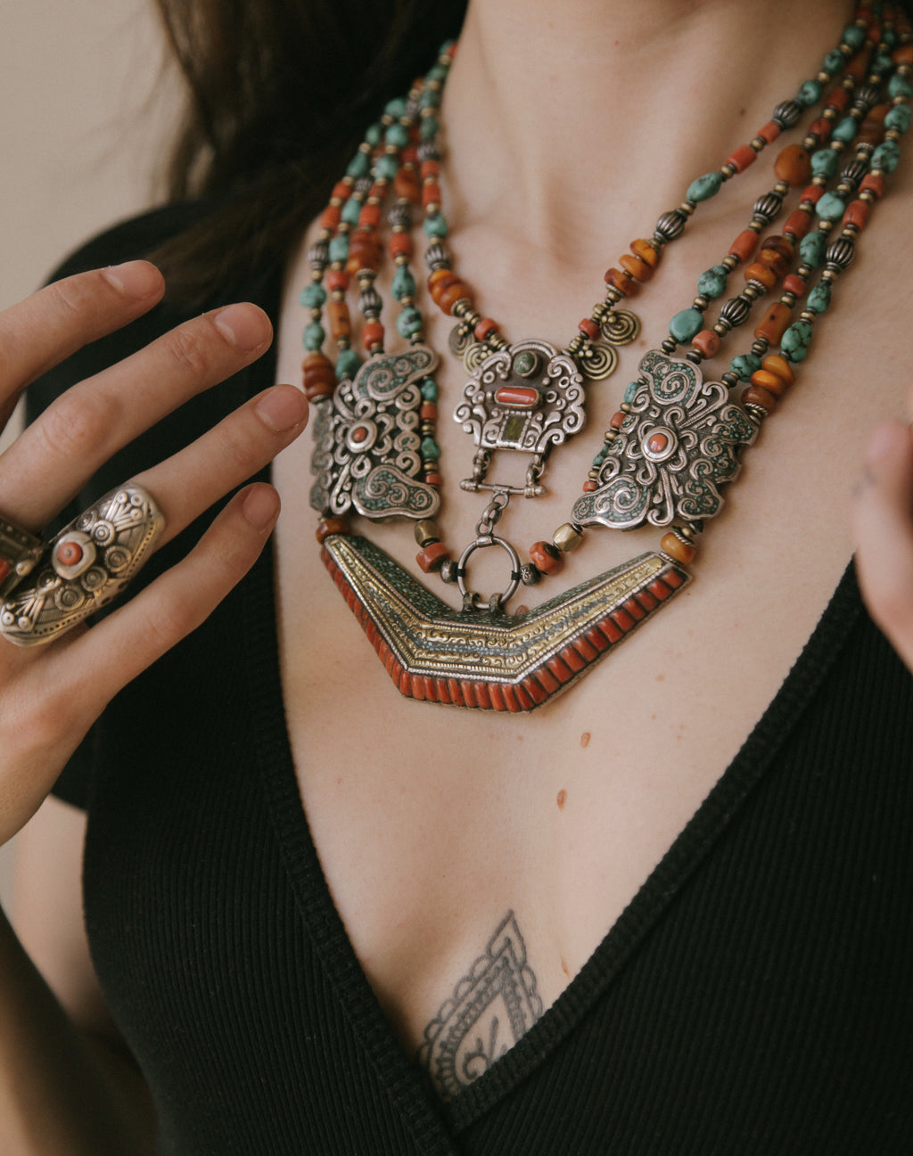 Collar de Tíbet hecho a mano con un maravilloso detalle en el labrado de la plata( representando dos mariposas en los laterales ) engarzado con cuatro vueltas de cuentas de plata, bronce, coral, turquesa, y ámbar,  gemas favoritas de la joyería tradicional tibetana. El cierre con coral y turquesa. Longitud 55 cm Peso  190 g.Tibetan necklace.