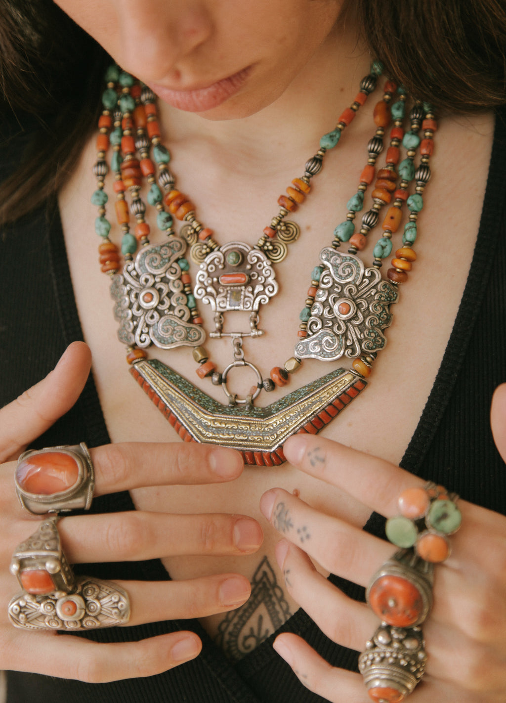 Collar de Tíbet hecho a mano con un maravilloso detalle en el labrado de la plata( representando dos mariposas en los laterales ) engarzado con cuatro vueltas de cuentas de plata, bronce, coral, turquesa, y ámbar,  gemas favoritas de la joyería tradicional tibetana. El cierre con coral y turquesa. Longitud 55 cm Peso  190 g.Tibetan necklace.