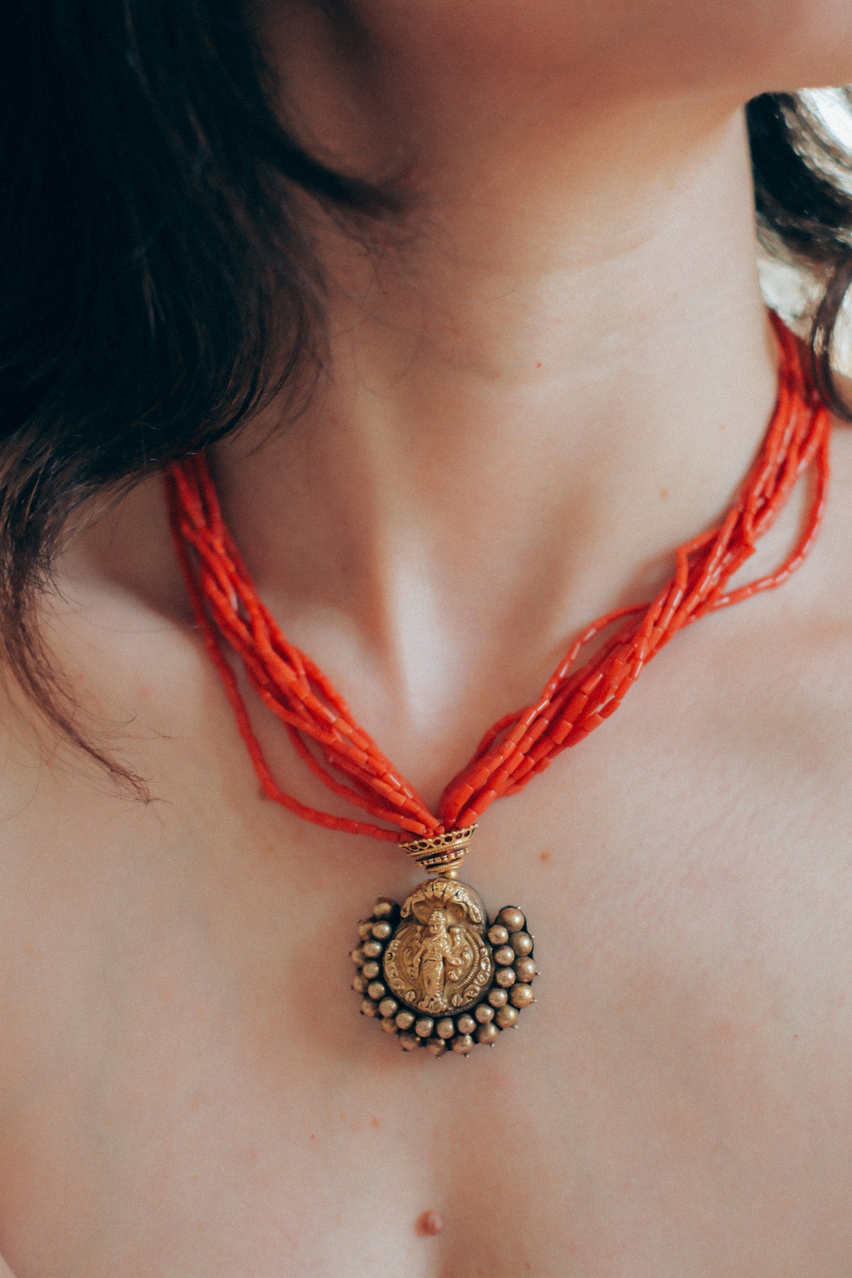 Collar con colgante antiguo de India de oro y metal en la parte posterior representando a Laksmi , diosa de la prosperidad material y espiritual para los hindúes, que simboliza la buena suerte. Esta combinado en esta pieza única de Lula Máiz con 9 vueltas de coral y cuentas de oro. El cierre es también de oro. Longitud 44 cm Medidas colgante 3´5 x 3´5 cm Peso 49 g One of a kind by Lula Máiz