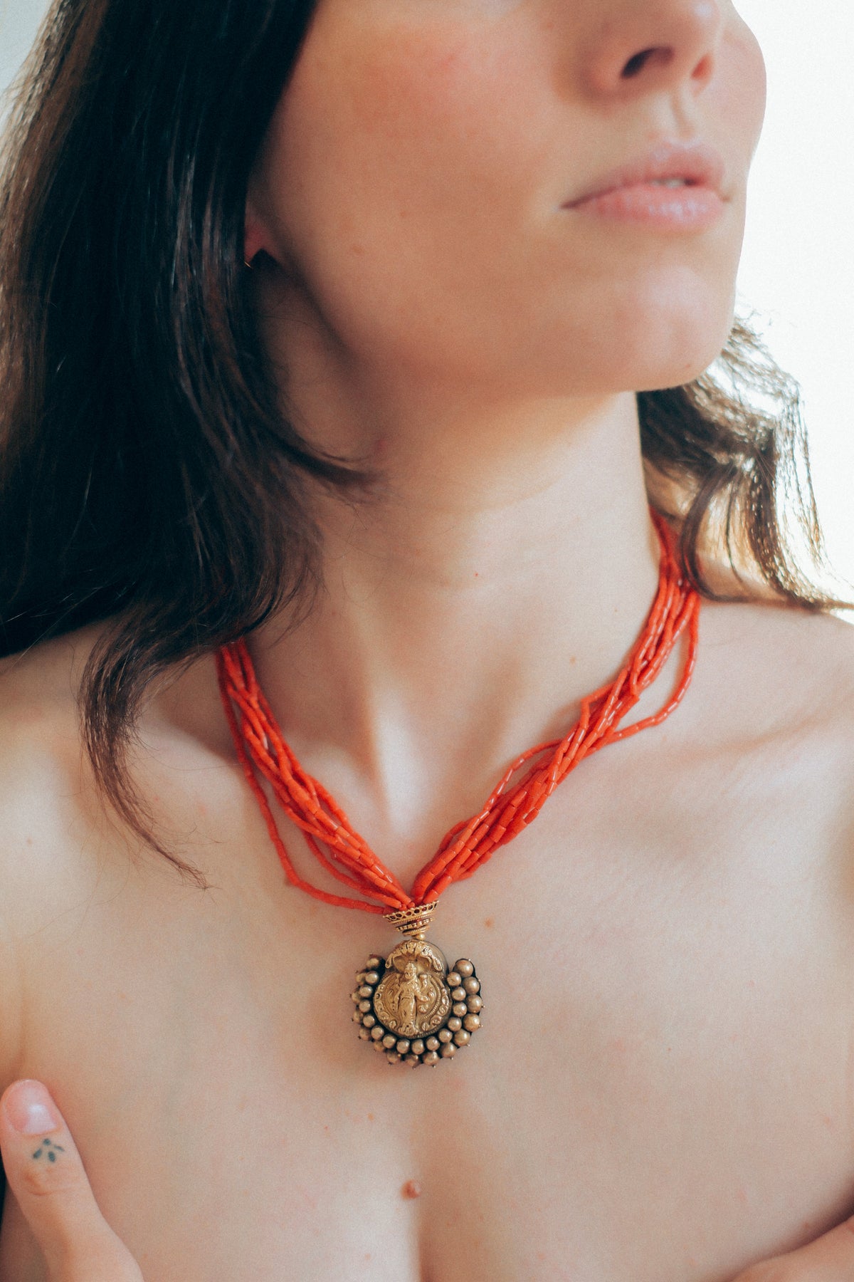 Collar con colgante antiguo de India de oro y metal en la parte posterior representando a Laksmi , diosa de la prosperidad material y espiritual para los hindúes, que simboliza la buena suerte. Esta combinado en esta pieza única de Lula Máiz con 9 vueltas de coral y cuentas de oro. El cierre es también de oro. Longitud 44 cm Medidas colgante 3´5 x 3´5 cm Peso 49 g One of a kind by Lula Máiz