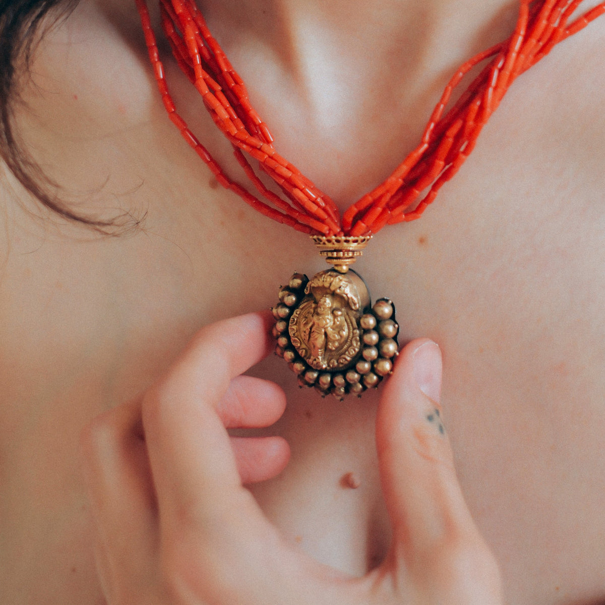 Collar con colgante antiguo de India de oro y metal en la parte posterior representando a Laksmi , diosa de la prosperidad material y espiritual para los hindúes, que simboliza la buena suerte. Esta combinado en esta pieza única de Lula Máiz con 9 vueltas de coral y cuentas de oro. El cierre es también de oro. Longitud 44 cm Medidas colgante 3´5 x 3´5 cm Peso 49 g One of a kind by Lula Máiz