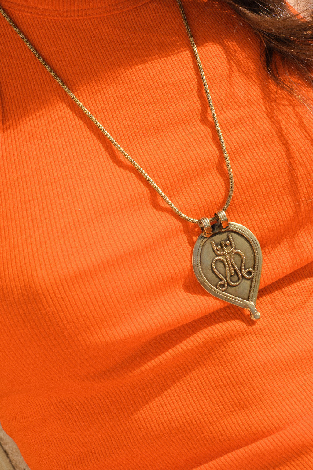 Antiguo amuleto de India en plata dorada con una serpiente y un tridente, símbolos de Shiva, dios supremo del hinduismo que crea, protege y transforma el universo. La cadena artesanal hecha a mano con plata de ley y baño de oro. Colgante.  Medidas 6 cm x 4 cm. Peso 13 g. Cadena. Longitud 66 cm. Grosor 2 mm Old Shiva amulet. Old indian amulets. Lula Máiz