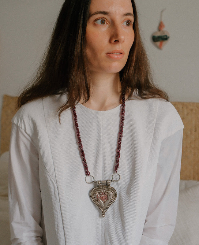 Collar diseñado por Lula Máiz con antiguo colgante de India, de plata representando dos pavos reales , ave que en la mitología hindú esta asociada con Lakshmi , la diosa de la prosperidad, belleza y compasión. Esta engarzado en esta pieza única con varias vueltas de granates. El cierre es contemporaneo, de plata. Longitud 73 cm Medidas colgante 8 cm x 6 cm Peso 140 gr.One of a kind by Lula Maiz