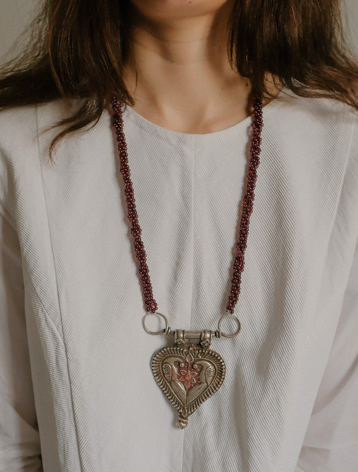 Collar diseñado por Lula Máiz con antiguo colgante de India, de plata representando dos pavos reales , ave que en la mitología hindú esta asociada con Lakshmi , la diosa de la prosperidad, belleza y compasión. Esta engarzado en esta pieza única con varias vueltas de granates. El cierre es contemporaneo, de plata. Longitud 73 cm Medidas colgante 8 cm x 6 cm Peso 140 gr.One of a kind by Lula Maiz