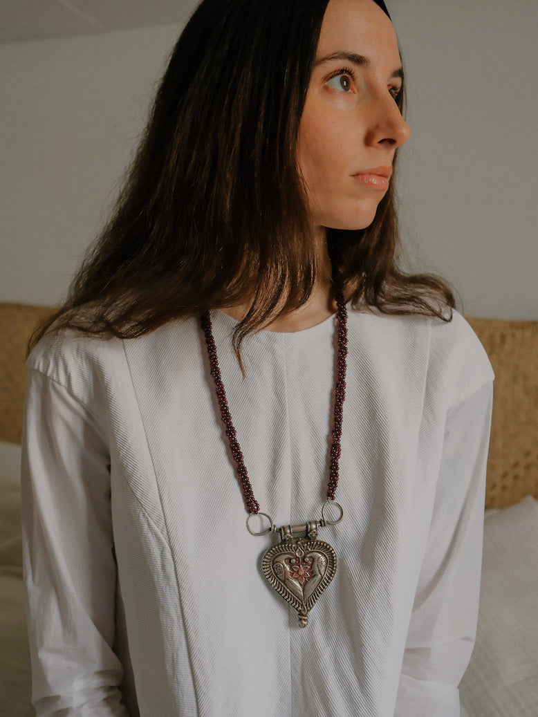 Collar diseñado por Lula Máiz con antiguo colgante de India, de plata representando dos pavos reales , ave que en la mitología hindú esta asociada con Lakshmi , la diosa de la prosperidad, belleza y compasión. Esta engarzado en esta pieza única con varias vueltas de granates. El cierre es contemporaneo, de plata. Longitud 73 cm Medidas colgante 8 cm x 6 cm Peso 140 gr.One of a kind by Lula Maiz