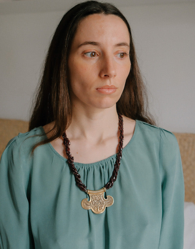Collar con colgante artesanal hecho a mano con plata de ley dorada y motivos florales, combinada con cuatro vueltas de granates facetados. El cierre es tambien artesanal , de plata de ley dorada. Longitud aproximada 60 cm Medidas colgante 45 cm x 70 cm Peso 120 gr One of a kind by Lula Maiz.