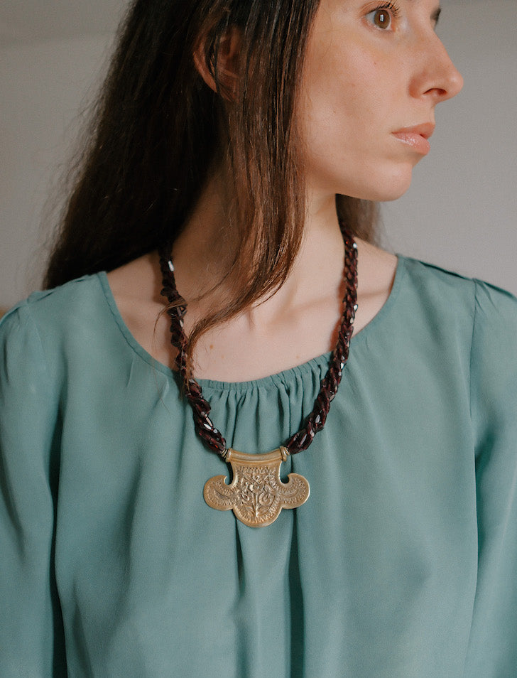 Collar con colgante artesanal hecho a mano con plata de ley dorada y motivos florales, combinada con cuatro vueltas de granates facetados. El cierre es tambien artesanal , de plata de ley dorada. Longitud aproximada 60 cm Medidas colgante 45 cm x 70 cm Peso 120 gr One of a kind by Lula Maiz.
