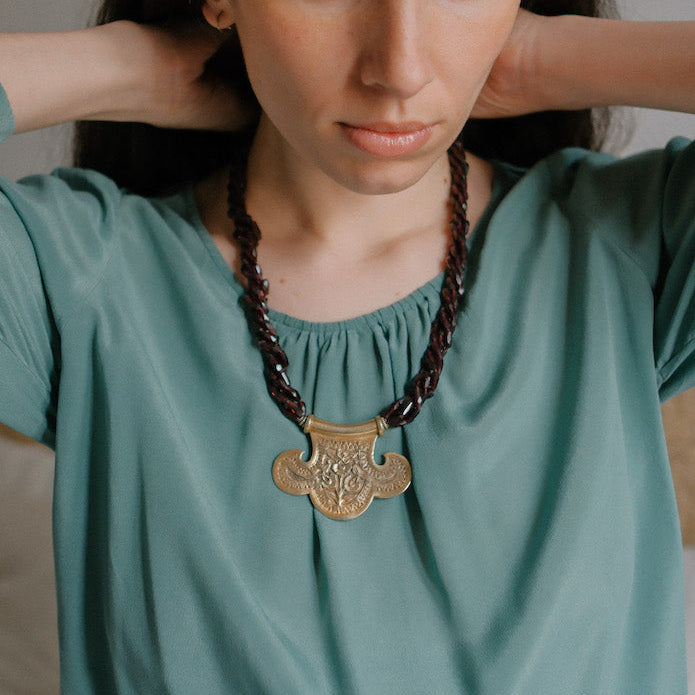 Collar con colgante artesanal hecho a mano con plata de ley dorada y motivos florales, combinada con cuatro vueltas de granates facetados. El cierre es tambien artesanal , de plata de ley dorada. Longitud aproximada 60 cm Medidas colgante 45 cm x 70 cm Peso 120 gr One of a kind by Lula Maiz.