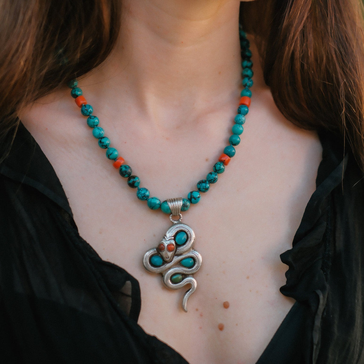 Collar con turquesas, coral y colgante tibetano hecho a mano con plata, coral y turquesas, representando una serpiente, animal que simboliza la renovacion, transformacion y sabiduria. La parte posterior tiene un exquisito trabajo artesanal, y puede ser usado por ambos lados. El cierre es de plata de ley. Longitud 51 cm Peso 56 g One of a kind by Lula Máiz