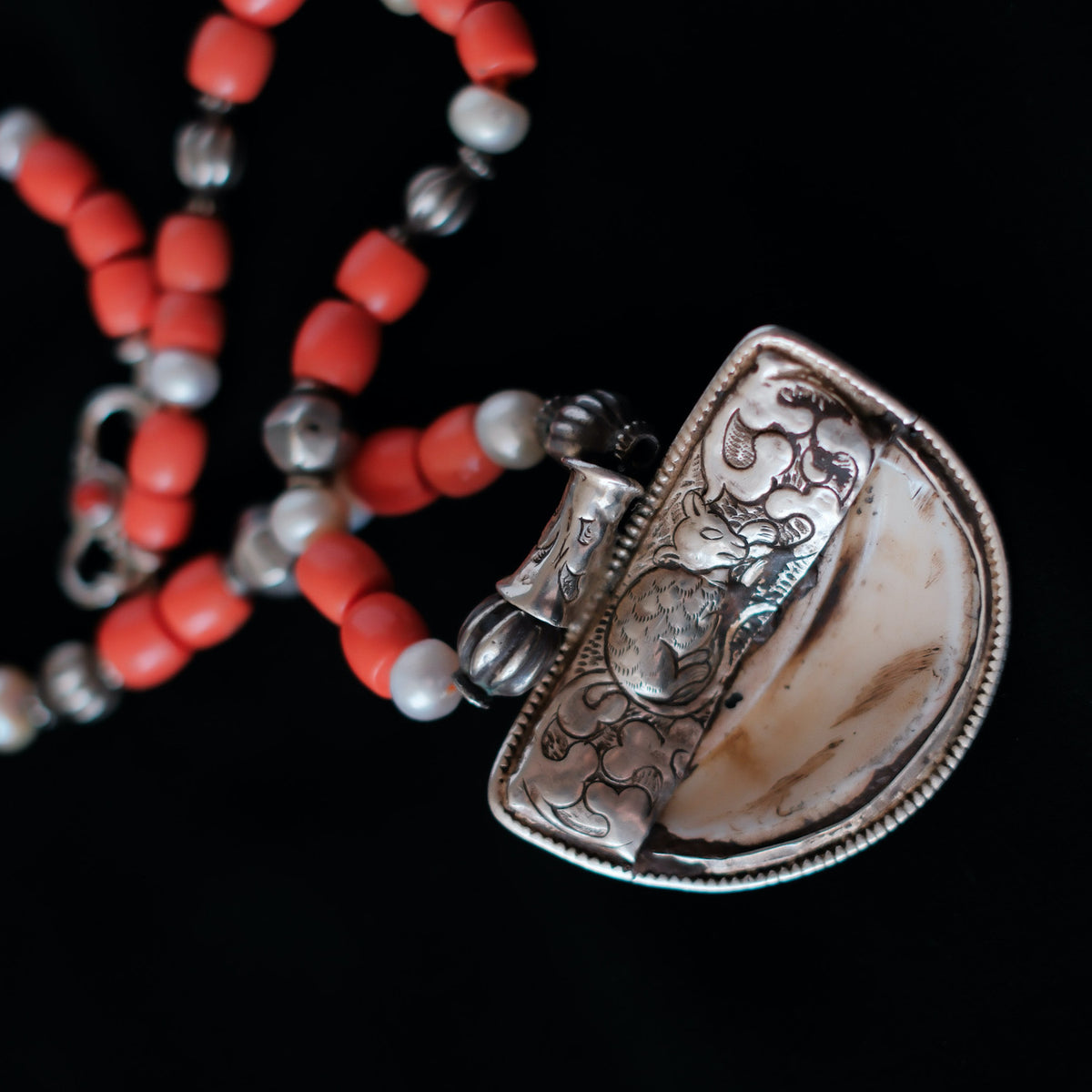 Colgante tibetano de concha, plata y coral, representando el Sol, que para el budismo representa la luz del Dharmakaya, que brilla en el interior del ser humano. Combinado en esta pieza única de Lula Máiz con cuentas de plata antiguas de India, perlas y madréporas. El cierre es de plata de ley y coral. Longitud 50 cm Peso 86 One of a kind by Lula Máiz