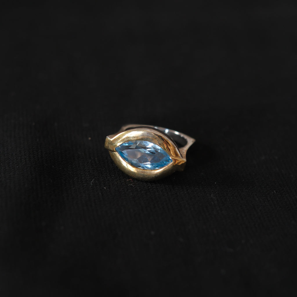 Anillo artesanal de diseño contemporáneo hecho a mano con plata de ley, oro y topacio azul facetado. Tamaño 17 Peso 12 g. Ring hand made with silver, gold and blue topaz. Lula Máiz