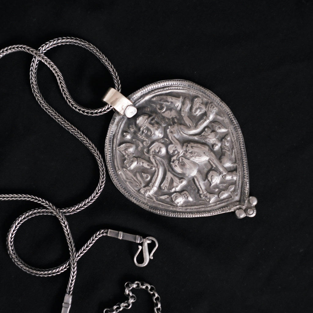 Colgante antiguo de India de gran tamaño , representando a Shiva, dios supremo en la mitología hindú, dios supremo del hinduismo que crea, protege y transforma el universo, gran asceta , considerado el dios del yoga, meditación y las artes. El colgante tiene una patina excelente. La cadena esta también hecha a mano con plata de ley .La parte superior del colgante ha sido recubierta con oro de 18 k. Medidas colgante 10 x 7´5 cm Longitud cadena 64 a 80 cm Peso 110 g. Old amulet with Shiva. Lula Máiz