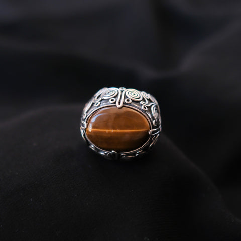 Anillo artesanal hecho a mano con plata de ley, gran cabujón de ojo de tigre y diseño de la comunidad uigur de Kashgar, importante centro en la ruta de la seda. Tamaño 17 Medidas ojo de tigre 25 mm x 18 mm Peso 32 g. Kashgar silver ring with big tiger eye cabochon. Lula Máiz