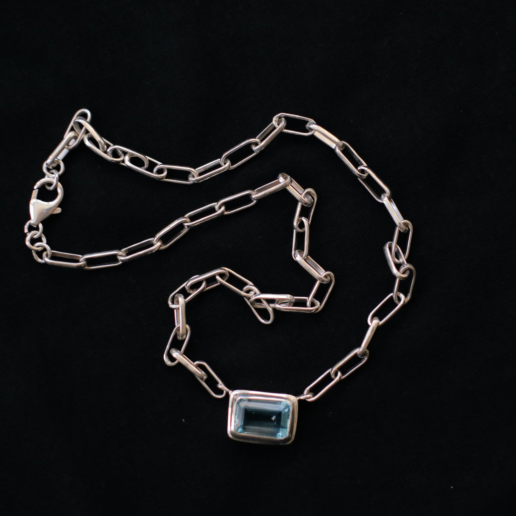 Cadena de eslabones hecha a mano con plata de ley y un topacio azul facetado. El cierre es de mosquetón. Longitud 41 cm Peso 18 g Medidas topacio 15 mm x 10 mm  Handcrafted link chain with blue topaz. Lula Máiz