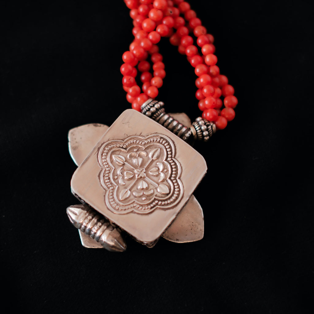 Collar con ghau ,colgante caja amuleto de plata y coral tibetano, engarzado con cuatro vueltas de coral rojo y cuentas de plata de ley. El cierre es también de plata y coral. Longitud 75 cm ( puede ajustarse enrollando las vueltas de coral en mayor o menor grado) Peso 100 g. One of a kind necklace by Lula M