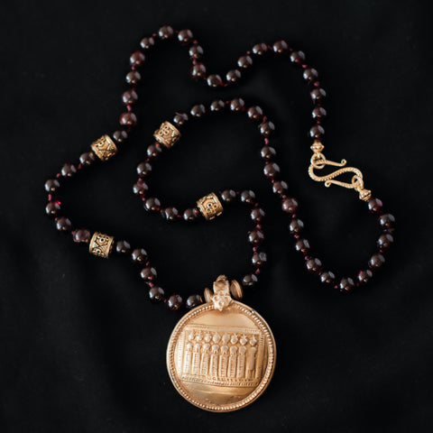 Collar de granates con antiguo amuleto en plata del Sur de India que representa a las diosas conocidas como las siete hermanas. que son una manifestación de la Madre Tierra y cuentas y cierre de plata de ley con baño de oro. Pieza única diseñada por Lula Máiz. Longitud 58 cm Peso 81 g. One of a kind necklace by Lula Máiz with garnets and old amulet with seven sisters from India
