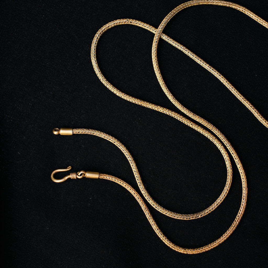 Antiguo amuleto de India en plata dorada con una serpiente y un tridente, símbolos de Shiva, dios supremo del hinduismo que crea, protege y transforma el universo. La cadena artesanal hecha a mano con plata de ley y baño de oro. Colgante.  Medidas 6 cm x 4 cm. Peso 13 g. Cadena. Longitud 66 cm. Grosor 2 mm Old Shiva amulet. Old indian amulets. Lula Máiz
