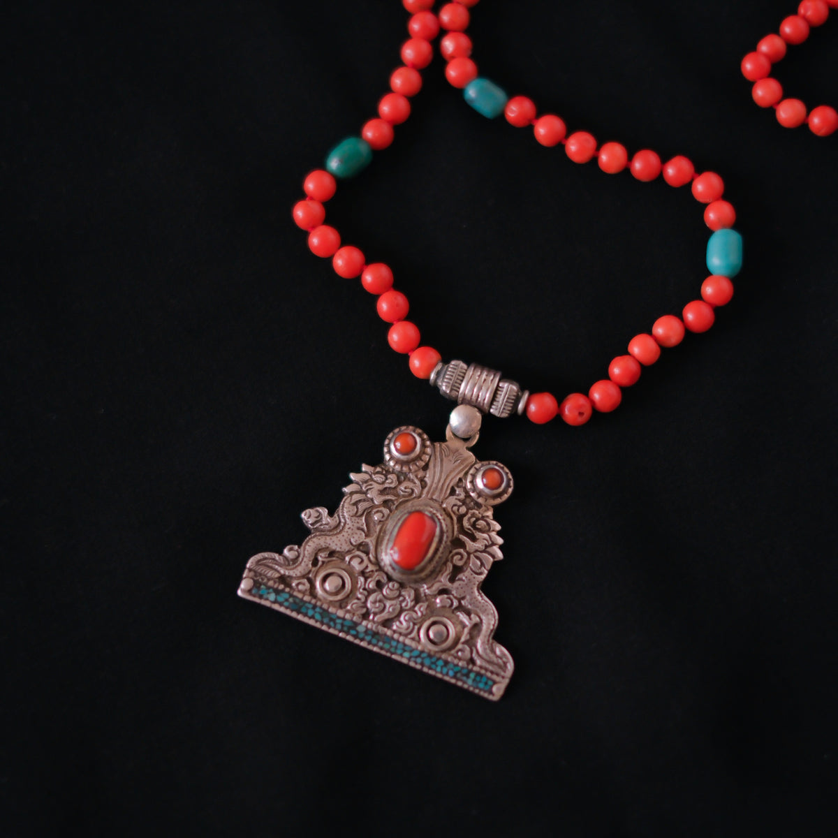 Collar con colgante tibetano de plata hecho a mano representando dos dragones, animal mitológico que para los budistas representa buena suerte, fuerza y salud. Combinado en esta pieza única de Lula Máiz con coral y turquesa. El cierre es de plata de ley. Longitud 60 cm Peso 32 g One of a kind by Lula Máiz