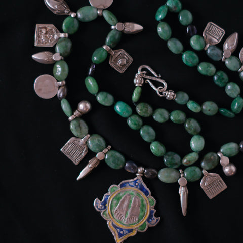 Collar con esmeraldas y antiguo amuleto de plata y esmalte caracteristico de Himachal Pradesh, estado indio situado en las faldas de los Himalayas, representando los pies de Vishnu . Combinado en esta pieza unica de Lula Maiz con antiguos amuletos y monedas de plata de India. Longitud 72 cm Peso 95 g  One of a kind by Lula Maiz