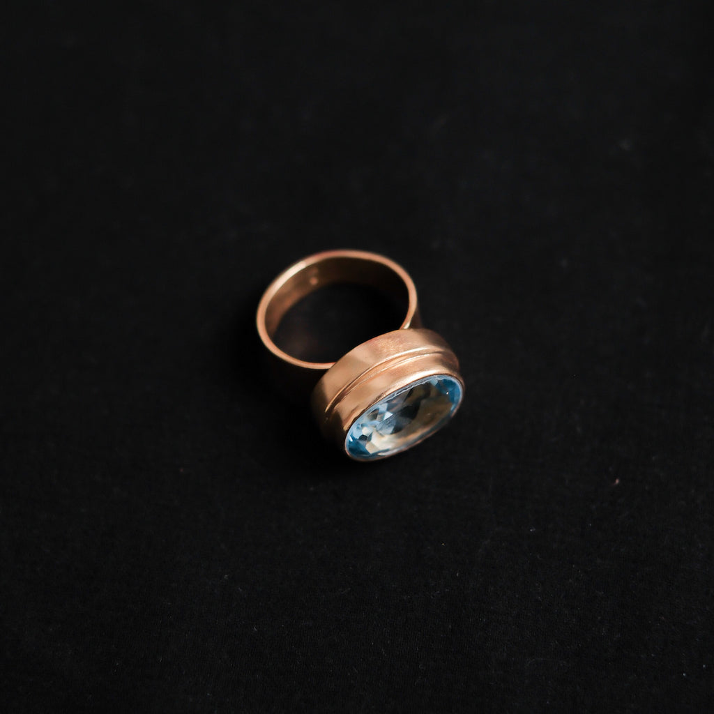 Anillo artesanal hecho a mano con plata de ley, baño de oro mateado y topacio azul facetado. Peso  11 g. Medidas topacio 15 mm x 10 mm Hand made gold plated silver ring with blue topaz. Lula Máiz