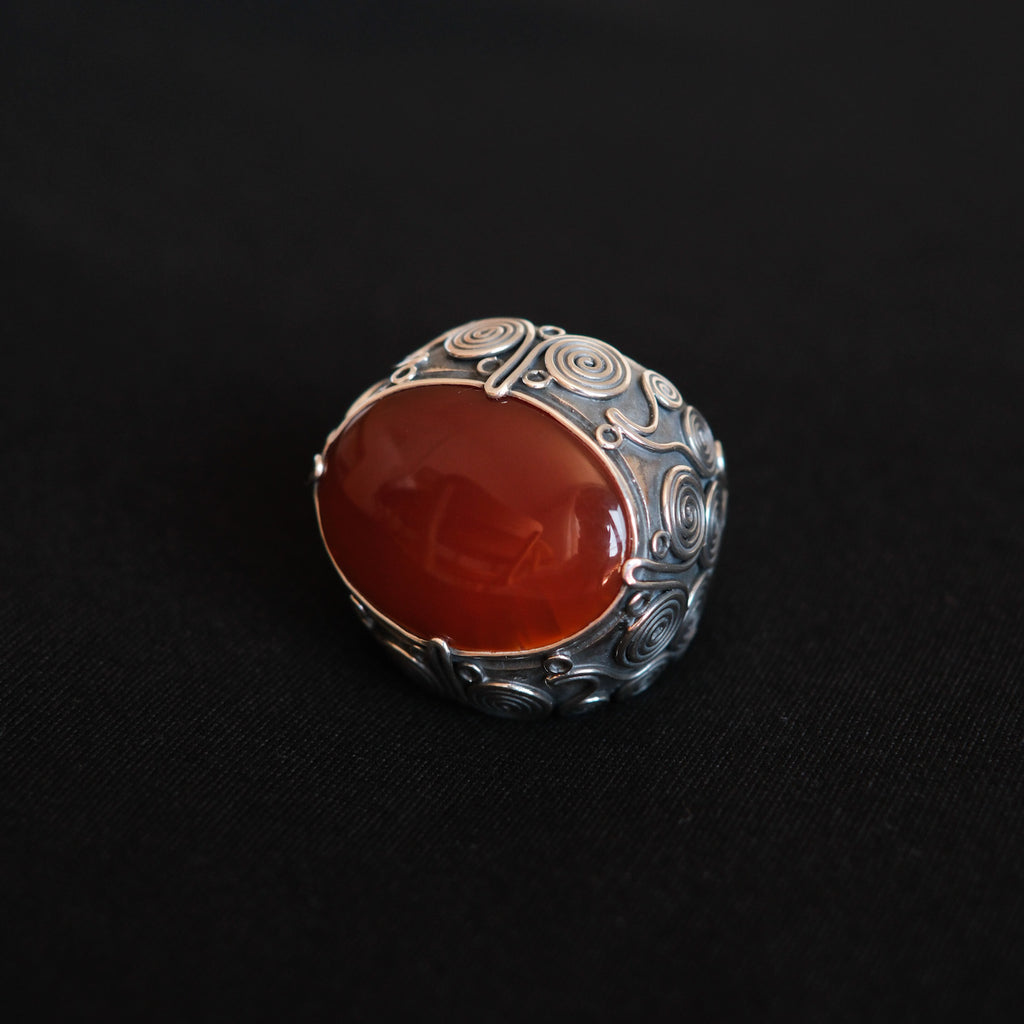 Anillo artesanal hecho a mano con plata de ley, gran cabujón de ágata carneola y diseño de la comunidad uigur de Kashgar,  importante centro en la ruta de la seda. Tamaño 18 Medidas cabujón  30 mm x 25 mm Peso 34 g Chunky silver rings. Silver ring with carnelian agate. Lula Máiz