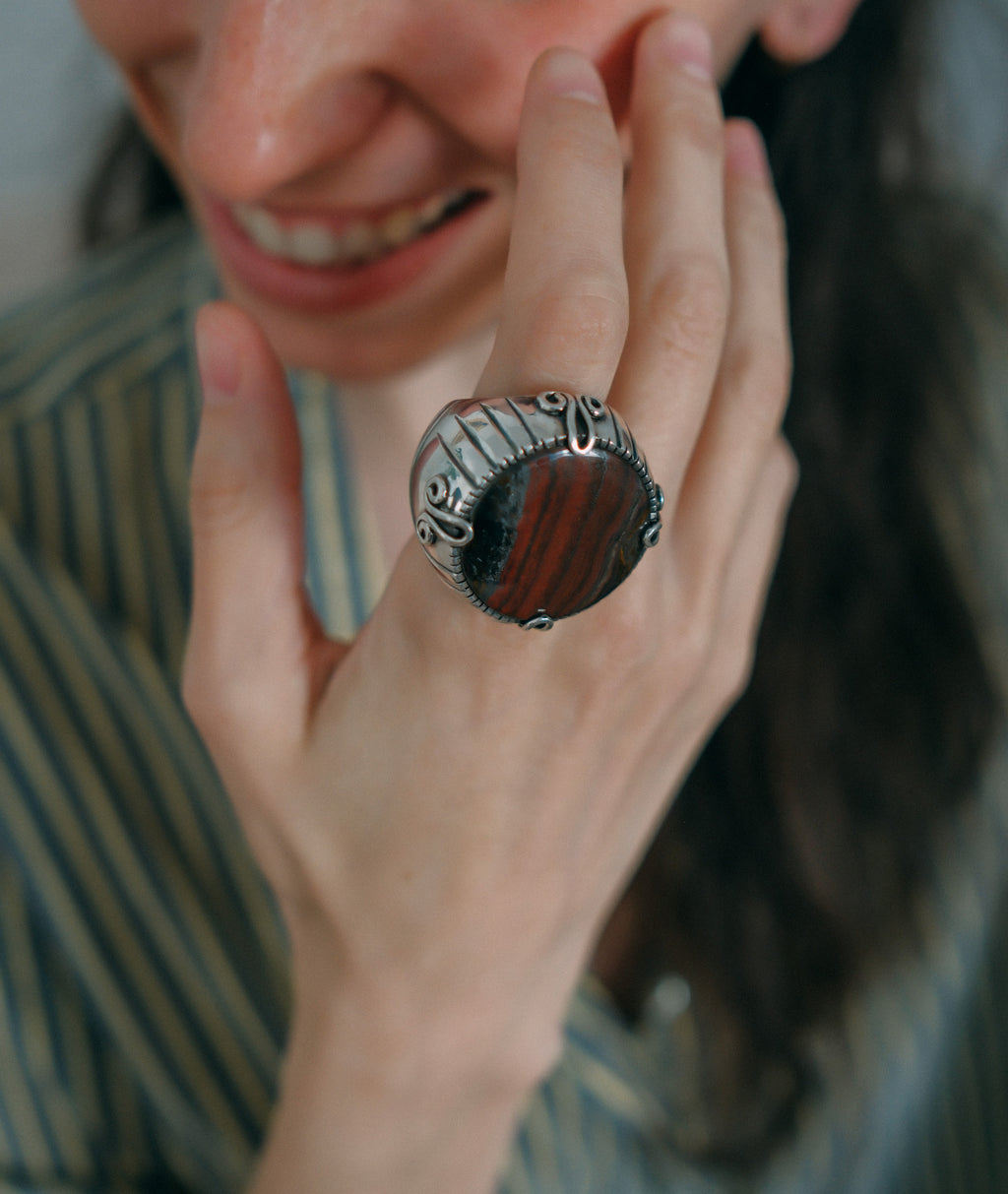 Anillo XL de diseño uigur, comunidad musulmana de Kashgar ( Sinkiang ), con un gran cabujón de piedra de hierro. Las espirales laterales simbolizan la eternidad. Hecho a mano con plata de ley. Tamaño 21 Diámetro 30 mm Peso 38 g.Handcrafted silver ring with tiger iron. Lula Máiz