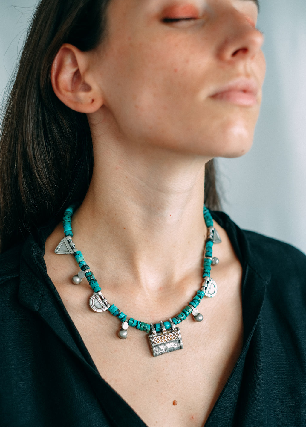 Collar con colgante antiguo de plata de India y amuletos telsum, usados por el grupo étnico Oromo de Etiopia como talismanes, los de forma triangular para proteger al portador del mal de ojo, y los semicirculares para atraer la protección de la luna. Estos están hechos de plata proveniente de la fundición de taleros de la emperatriz María Theresa de Austria. Combinados con turquesas y piezas de plata antiguas de Paquistán. One of a kind by Lula Máiz.