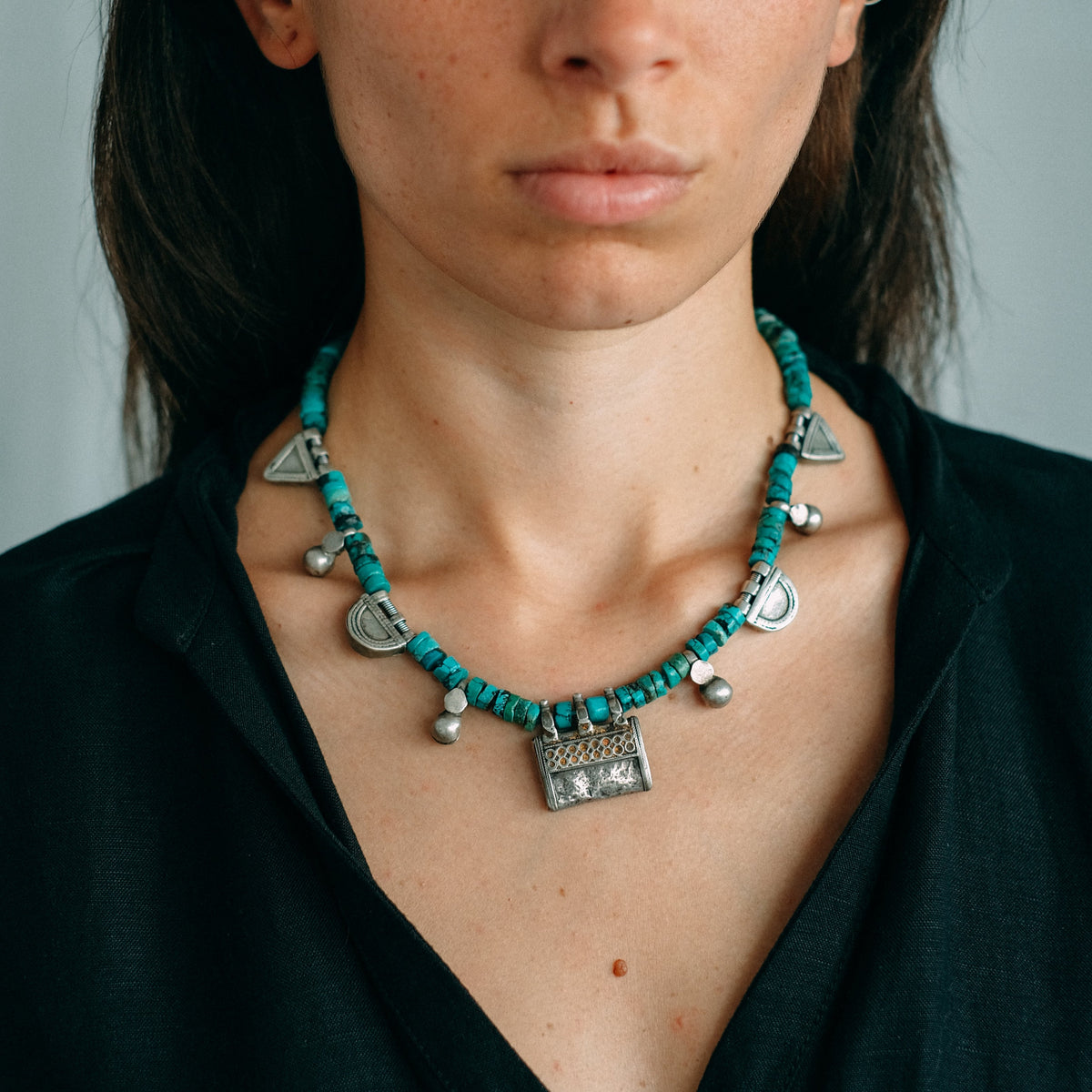 Collar con colgante antiguo de plata de India y amuletos telsum, usados por el grupo étnico Oromo de Etiopia como talismanes, los de forma triangular para proteger al portador del mal de ojo, y los semicirculares para atraer la protección de la luna. Estos están hechos de plata proveniente de la fundición de taleros de la emperatriz María Theresa de Austria. Combinados con turquesas y piezas de plata antiguas de Paquistán. One of a kind by Lula Máiz.