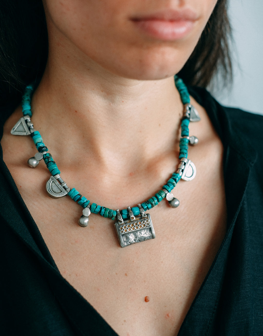 Collar con colgante antiguo de plata de India y amuletos telsum, usados por el grupo étnico Oromo de Etiopia como talismanes, los de forma triangular para proteger al portador del mal de ojo, y los semicirculares para atraer la protección de la luna. Estos están hechos de plata proveniente de la fundición de taleros de la emperatriz María Theresa de Austria. Combinados con turquesas y piezas de plata antiguas de Paquistán. One of a kind by Lula Máiz.