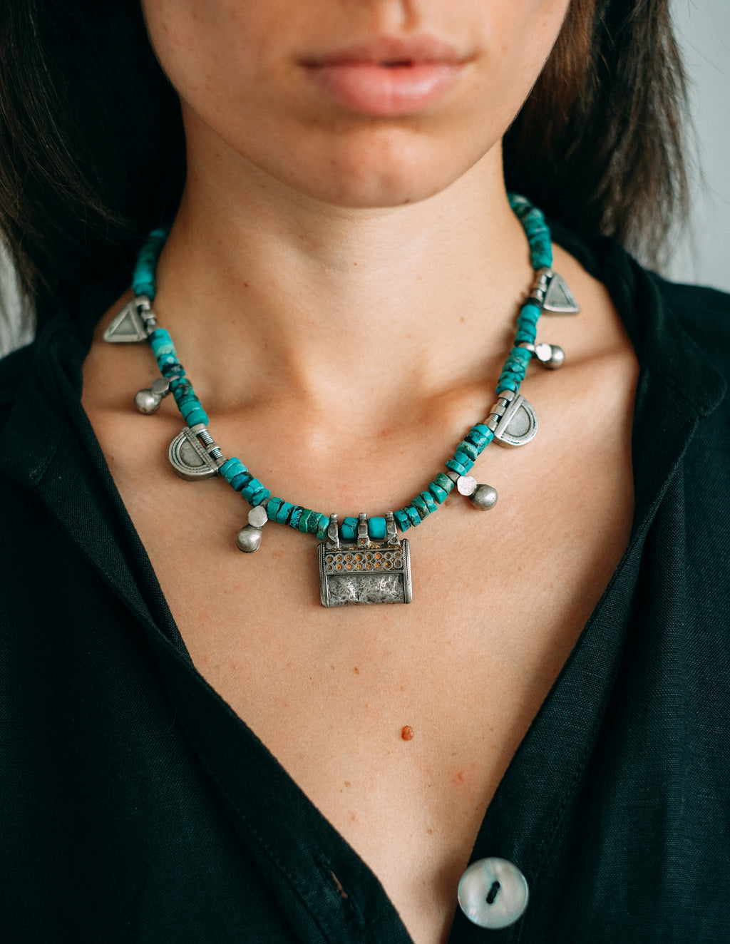 Collar con colgante antiguo de plata de India y amuletos telsum, usados por el grupo étnico Oromo de Etiopia como talismanes, los de forma triangular para proteger al portador del mal de ojo, y los semicirculares para atraer la protección de la luna. Estos están hechos de plata proveniente de la fundición de taleros de la emperatriz María Theresa de Austria. Combinados con turquesas y piezas de plata antiguas de Paquistán. One of a kind by Lula Máiz.