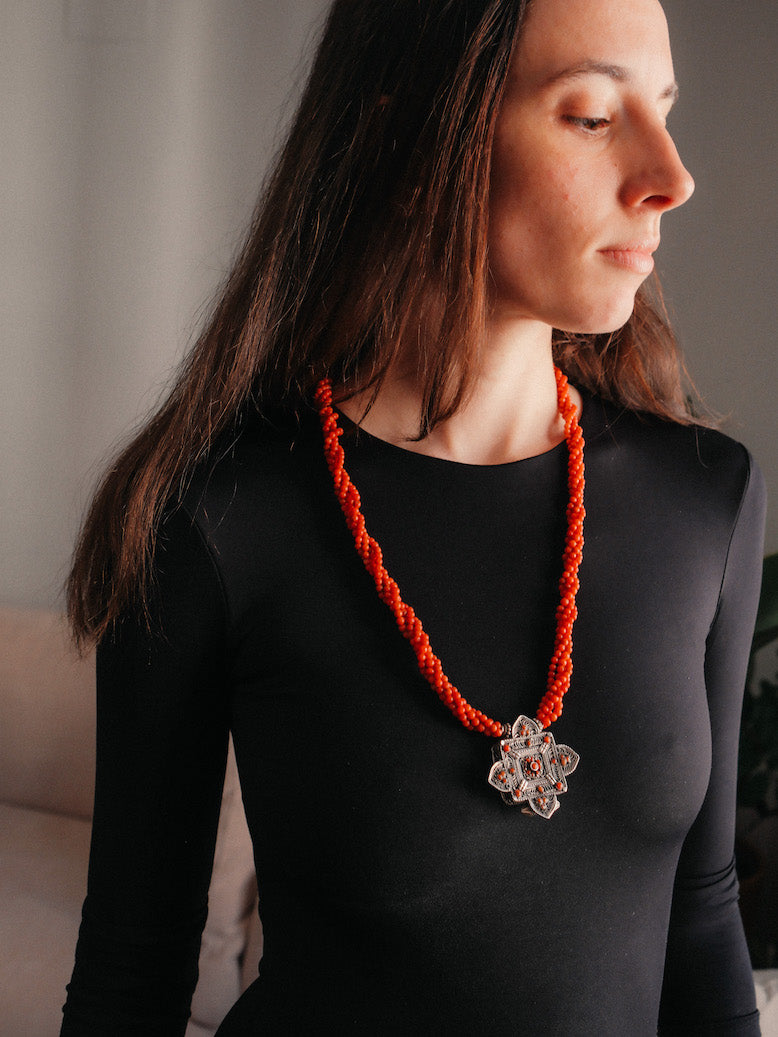 Collar con ghau ,colgante caja amuleto de plata y coral tibetano, engarzado con cuatro vueltas de coral rojo y cuentas de plata de ley. El cierre es también de plata y coral. Longitud 75 cm ( puede ajustarse enrollando las vueltas de coral en mayor o menor grado) Peso 100 g. One of a kind necklace by Lula M