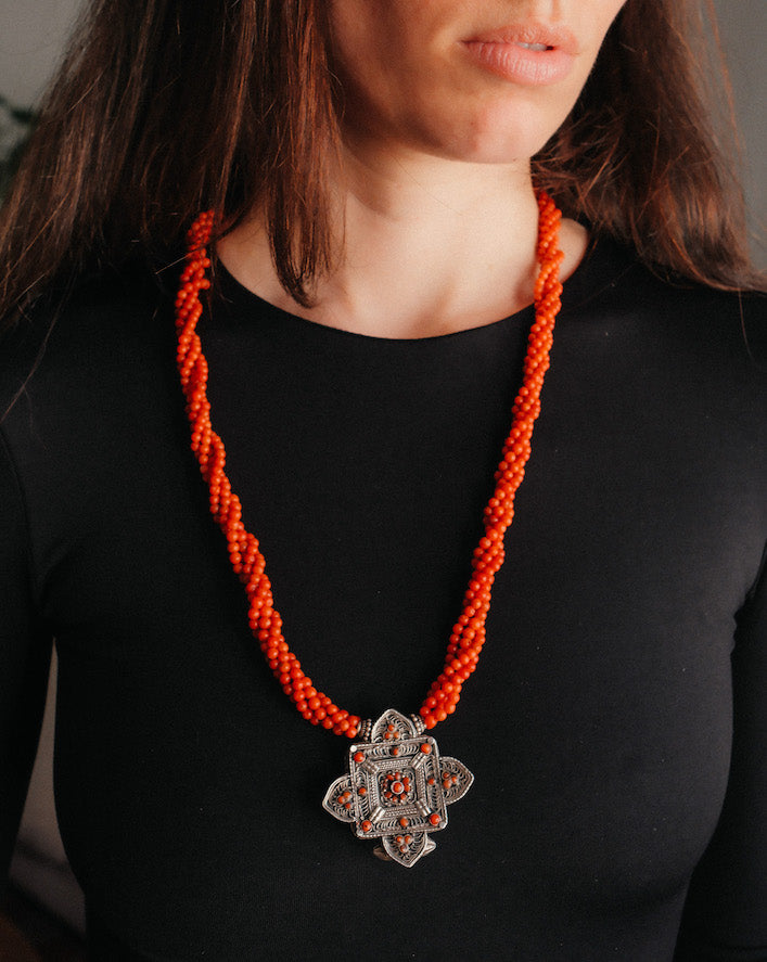 Collar con ghau ,colgante caja amuleto de plata y coral tibetano, engarzado con cuatro vueltas de coral rojo y cuentas de plata de ley. El cierre es también de plata y coral. Longitud 75 cm ( puede ajustarse enrollando las vueltas de coral en mayor o menor grado) Peso 100 g. One of a kind necklace by Lula M