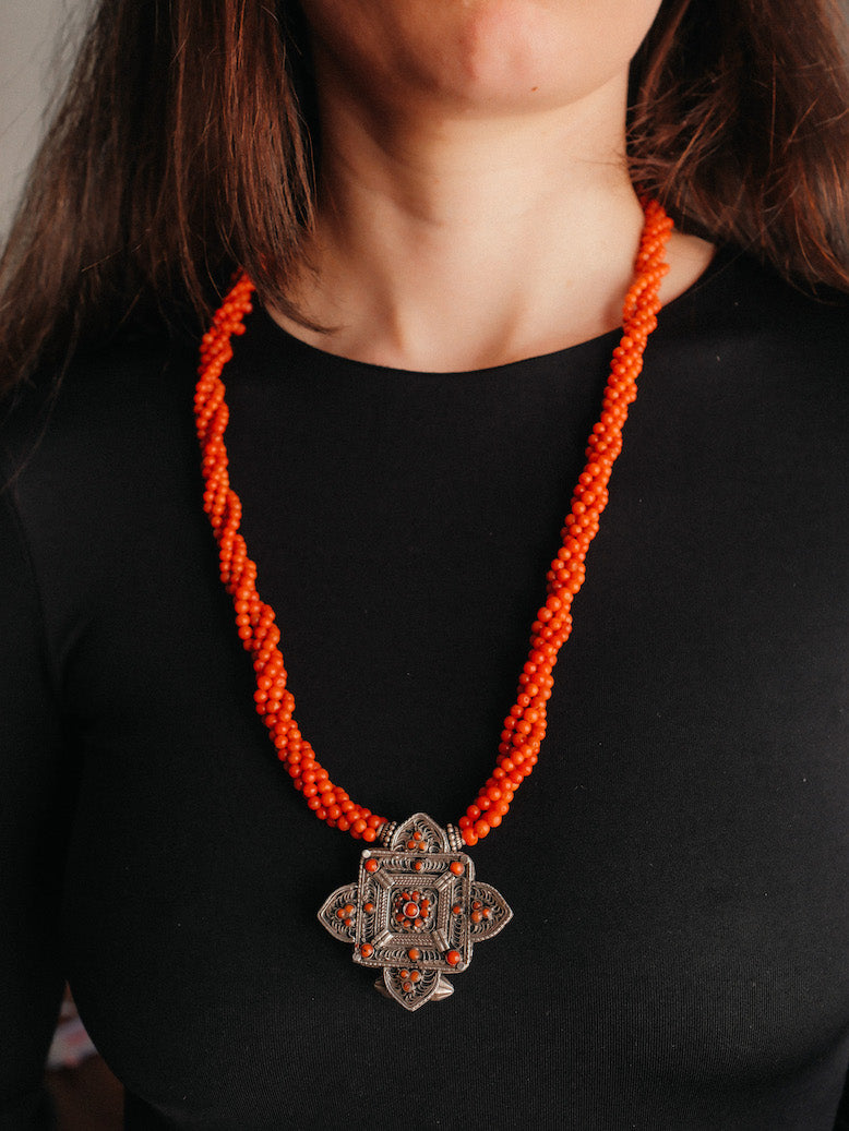 Collar con ghau ,colgante caja amuleto de plata y coral tibetano, engarzado con cuatro vueltas de coral rojo y cuentas de plata de ley. El cierre es también de plata y coral. Longitud 75 cm ( puede ajustarse enrollando las vueltas de coral en mayor o menor grado) Peso 100 g. One of a kind necklace by Lula M