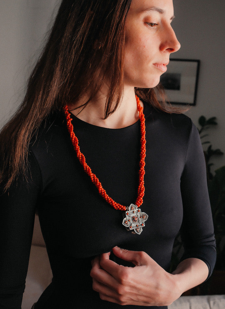 Collar con ghau ,colgante caja amuleto de plata y coral tibetano, engarzado con cuatro vueltas de coral rojo y cuentas de plata de ley. El cierre es también de plata y coral. Longitud 75 cm ( puede ajustarse enrollando las vueltas de coral en mayor o menor grado) Peso 100 g. One of a kind necklace by Lula M