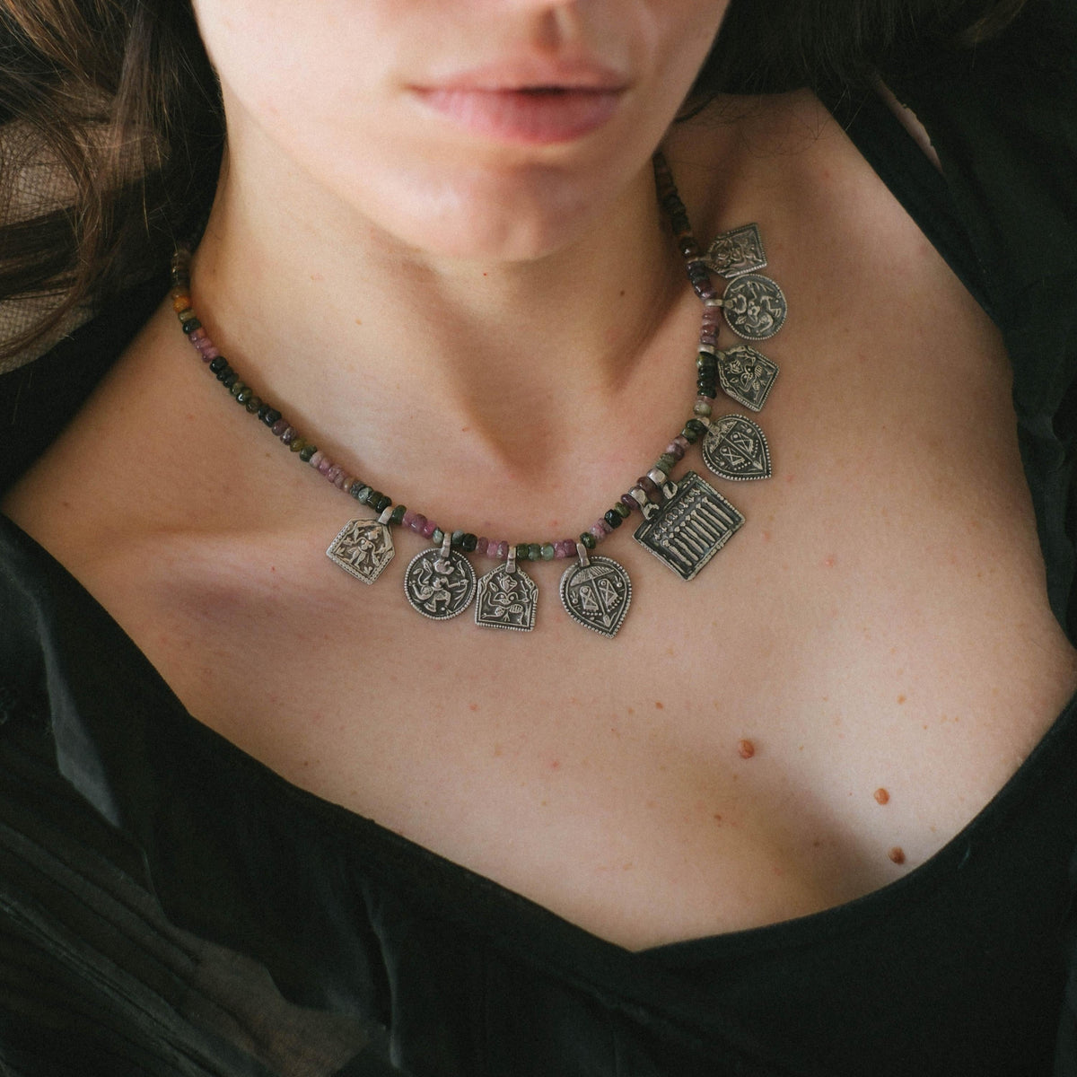 Collar con turmalinas multicolores y amuletos antiguos de India hechos con plata. Representan diversas deidades hindúes y tribales, como las Siete Hermanas, Hanuman el dios mono, las huellas del dios Vishnu, también conocido con el nombre de Narayana. El cierre es contemporáneo de plata de ley. Longitud 46 cm Peso 40 g. Pieza única, diseño de Lula Máiz. One of a kind by Lula Máiz