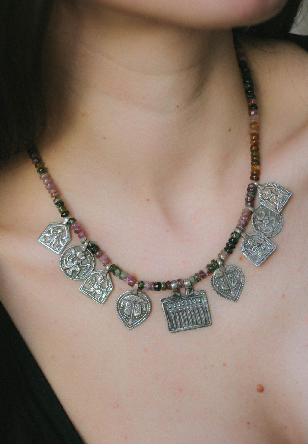 Collar con turmalinas multicolores y amuletos antiguos de India hechos con plata. Representan diversas deidades hindúes y tribales, como las Siete Hermanas, Hanuman el dios mono, las huellas del dios Vishnu, también conocido con el nombre de Narayana. El cierre es contemporáneo de plata de ley. Longitud 46 cm Peso 40 g. Pieza única, diseño de Lula Máiz. One of a kind by Lula Máiz