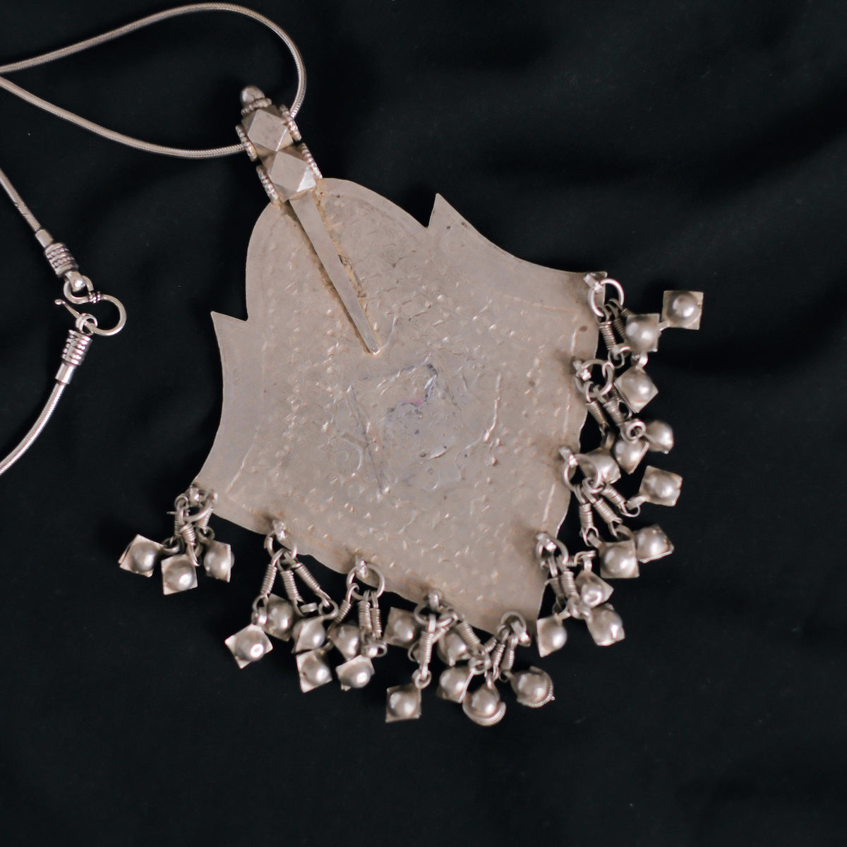 Colgante antiguo de Himachal Pradesh ( India ) hecho artesanalmente con plata y esmalte. La cadena es contemporánea, de plata de ley y se puede abrir desenroscando un extremo y usar con diferentes colgantes. Medidas colgante 13´5 x 10´5 cm Longitud cadena 80 cm. Peso 133 g. Old silver and enamel pendant from India. Lula Máiz