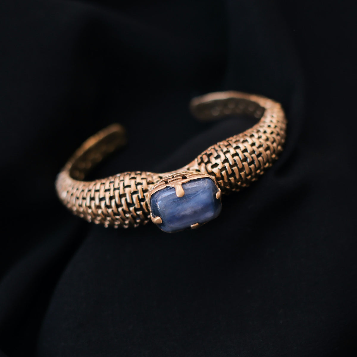 Pulsera artesanal hecha a mano con plata de ley, baño de oro mateado y cianita rectangular. Se abre con una bisagra escondida en el lateral. Contorno 17 cm Peso 33 g Cianita 20 mm x 15 mm Handcrafted bracelet with gold plated silver and kyanite. Lula Máiz