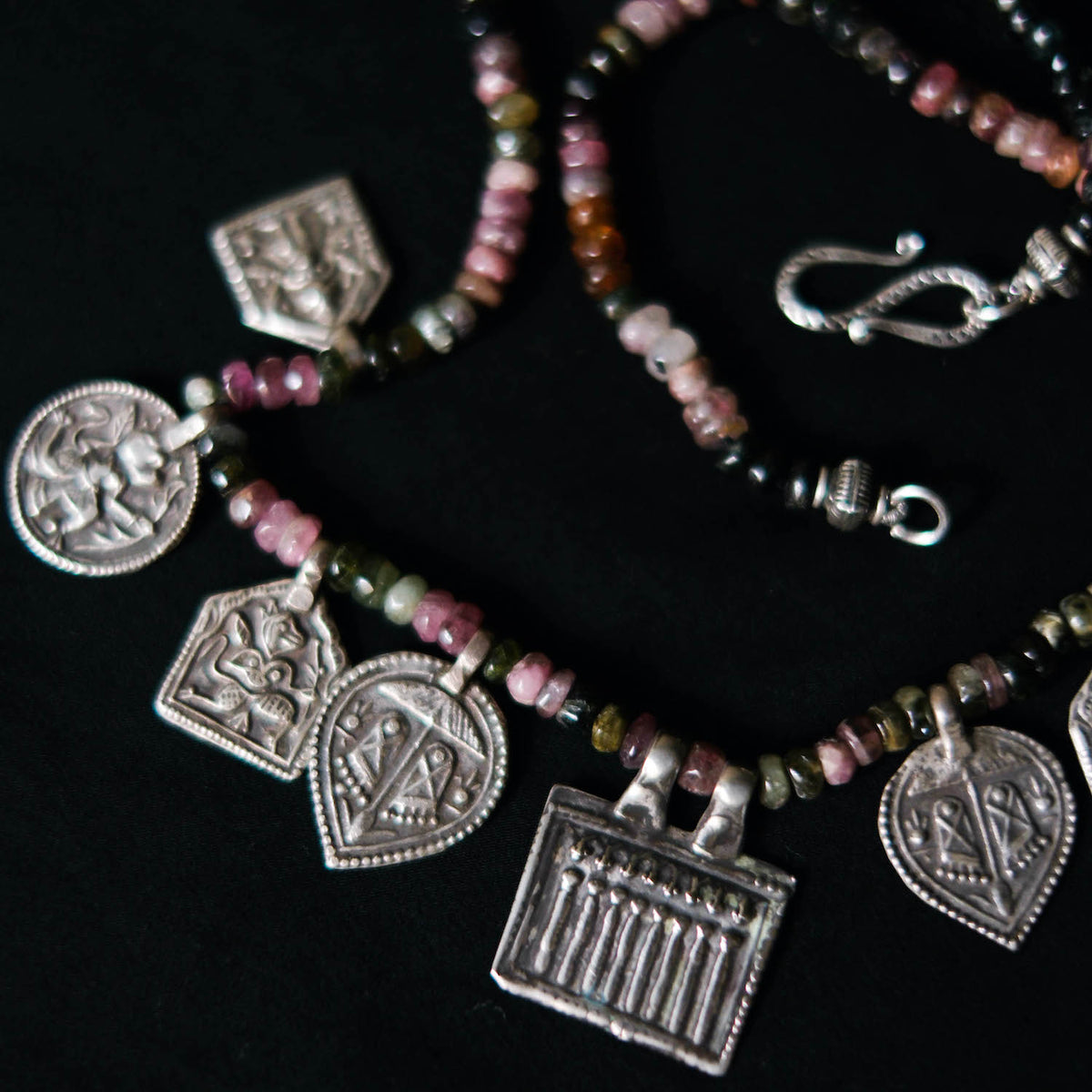 Collar con turmalinas multicolores y amuletos antiguos de India hechos con plata. Representan diversas deidades hindúes y tribales, como las Siete Hermanas, Hanuman el dios mono, las huellas del dios Vishnu, también conocido con el nombre de Narayana. El cierre es contemporáneo de plata de ley. Longitud 46 cm Peso 40 g. Pieza única, diseño de Lula Máiz. One of a kind by Lula Máiz