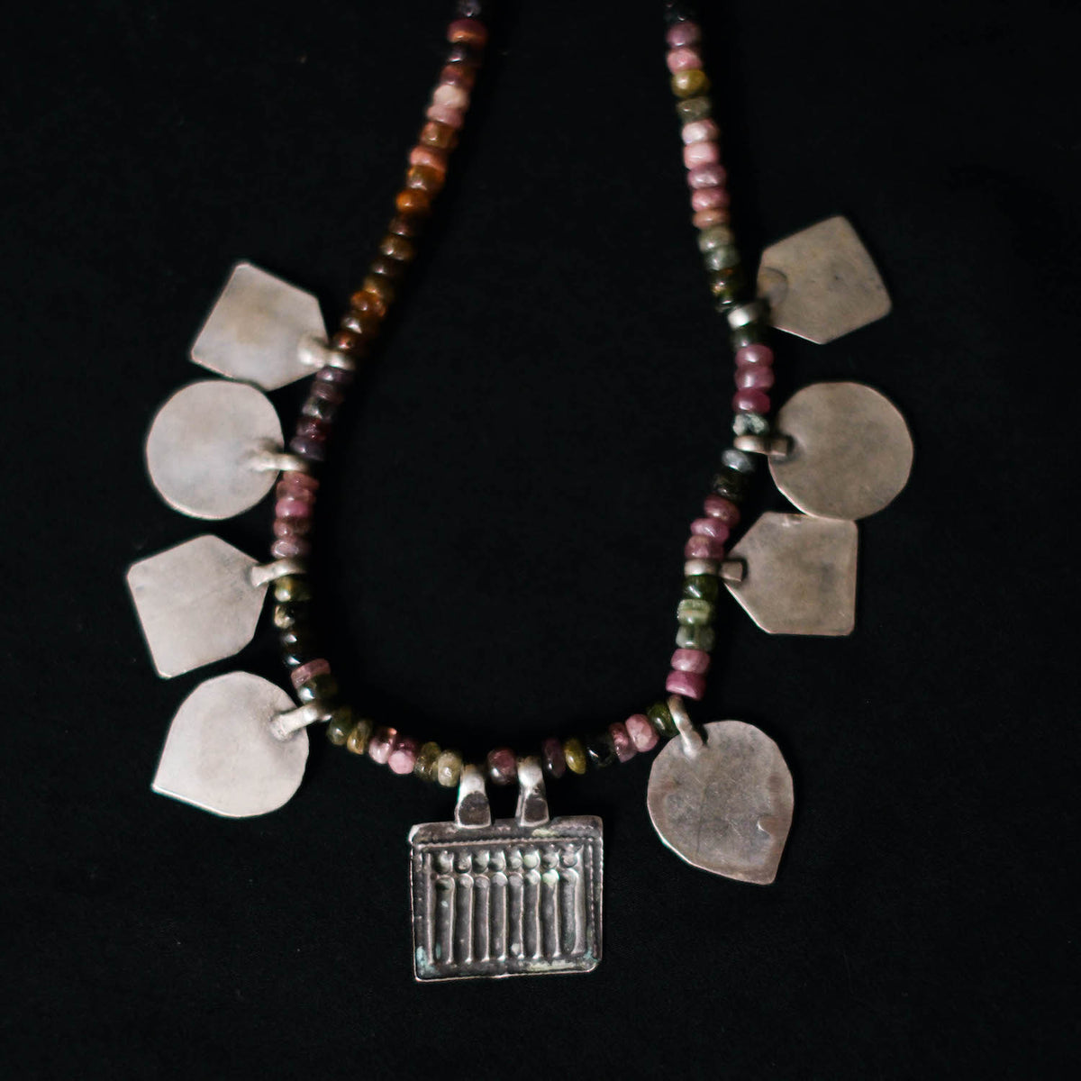 Collar con turmalinas multicolores y amuletos antiguos de India hechos con plata. Representan diversas deidades hindúes y tribales, como las Siete Hermanas, Hanuman el dios mono, las huellas del dios Vishnu, también conocido con el nombre de Narayana. El cierre es contemporáneo de plata de ley. Longitud 46 cm Peso 40 g. Pieza única, diseño de Lula Máiz. One of a kind by Lula Máiz
