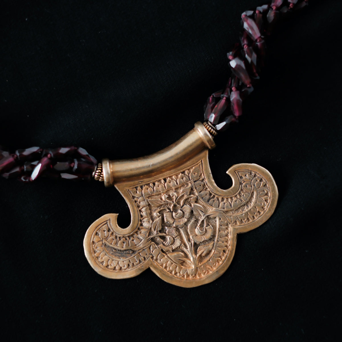 Collar con colgante artesanal hecho a mano con plata de ley dorada y motivos florales, combinada con cuatro vueltas de granates facetados. El cierre es tambien artesanal , de plata de ley dorada. Longitud aproximada 60 cm Medidas colgante 45 cm x 70 cm Peso 120 gr One of a kind by Lula Maiz.